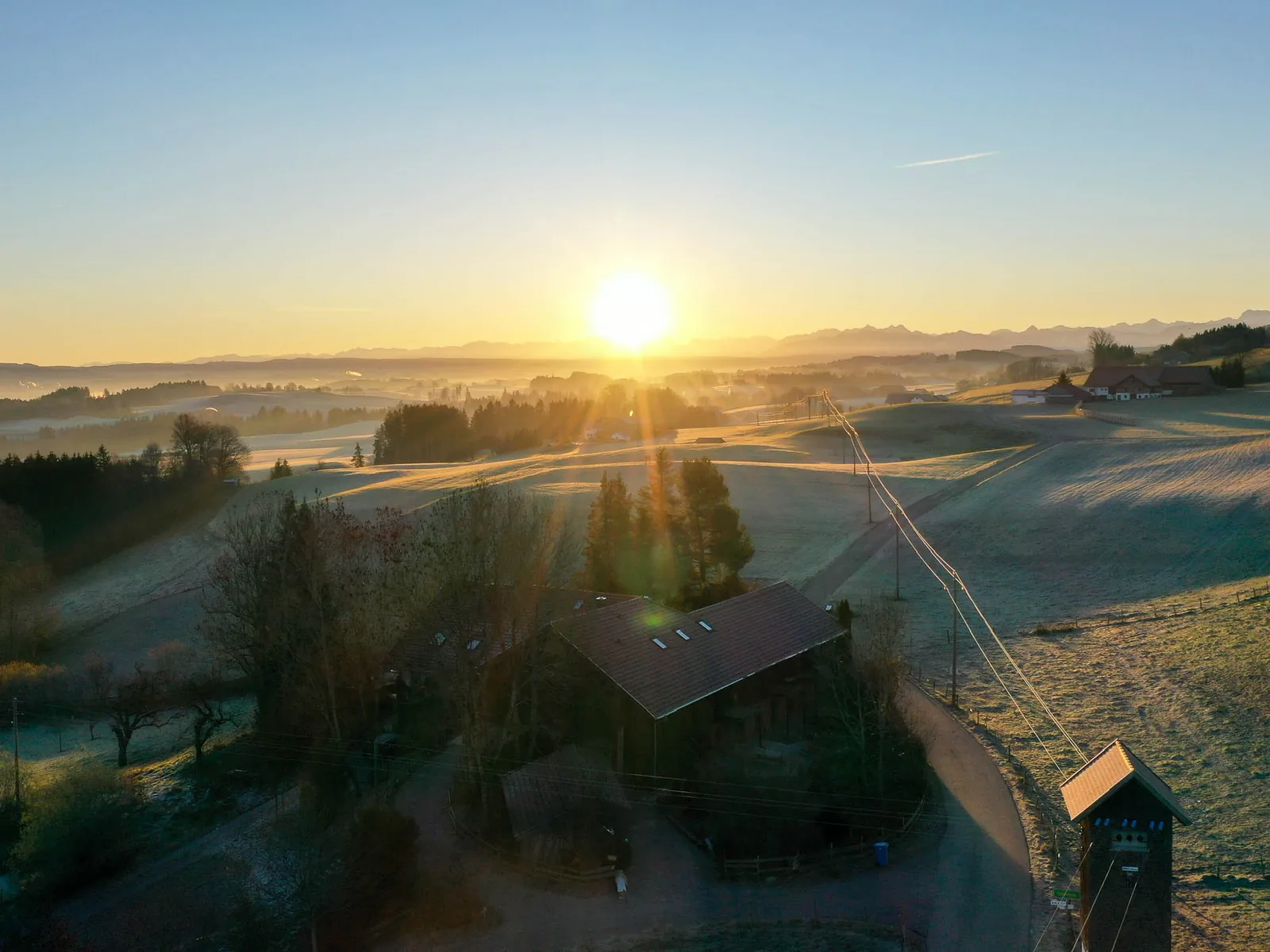 Der Hof im Morgenlicht über der weiten Voralpenlandschaft